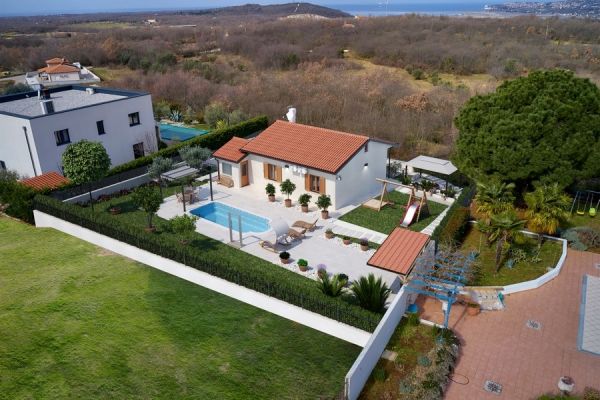 Aerial view of a charming, detached villa with a swimming pool in a green Croatian landscape - Buy a house in Croatia.