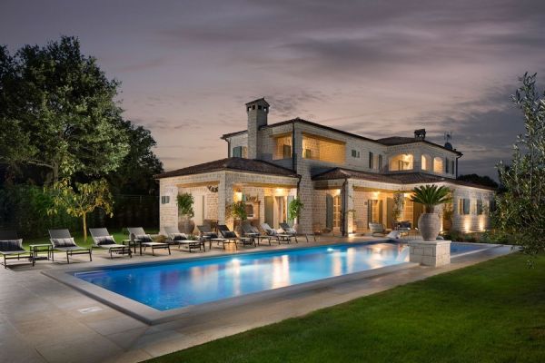 Luxurious stone villa with pool illuminated at night, an exclusive property for sale in Croatia