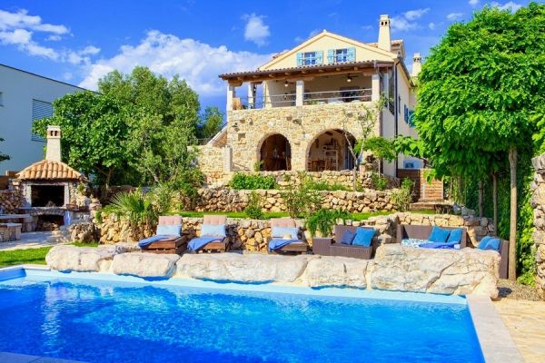 Outdoor swimming pool with built-in steps, flanked by natural stone walls, property on the island of Krk.
