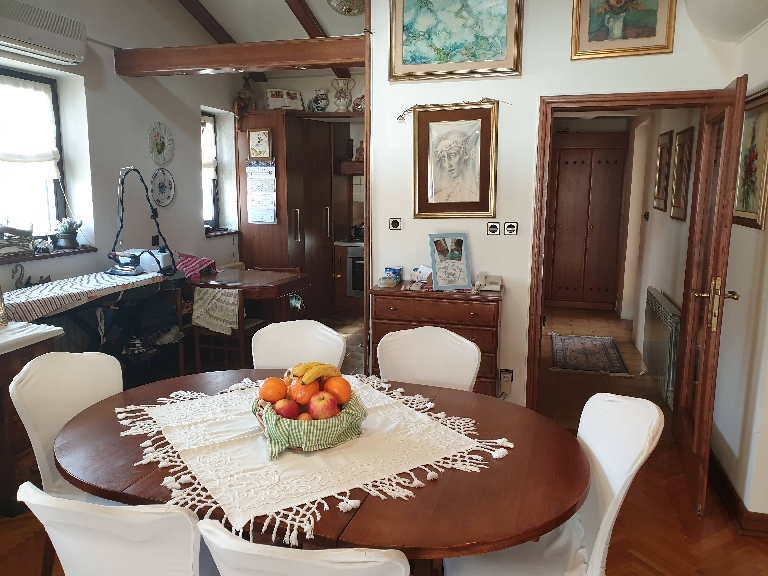 Dining table with a view of the kitchen and the hallway