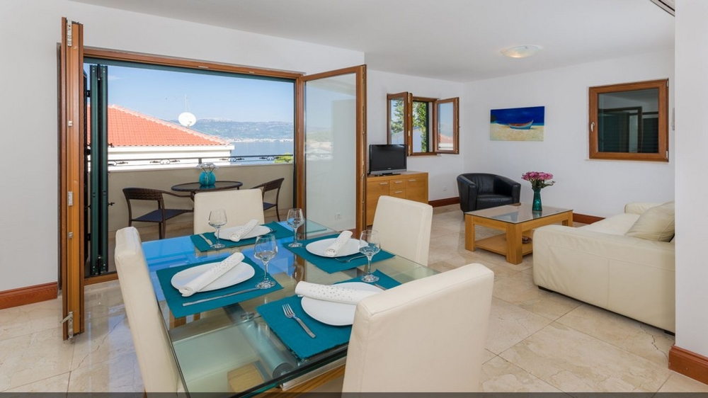 View of a living and dining area of ​​an apartment with a sea view - Buy an apartment in Croatia.
