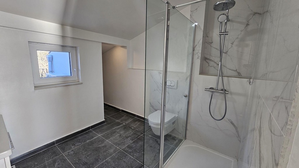Modern bathroom with shower and elegant fittings in an apartment for sale in Crikvenica, including a small window for natural light