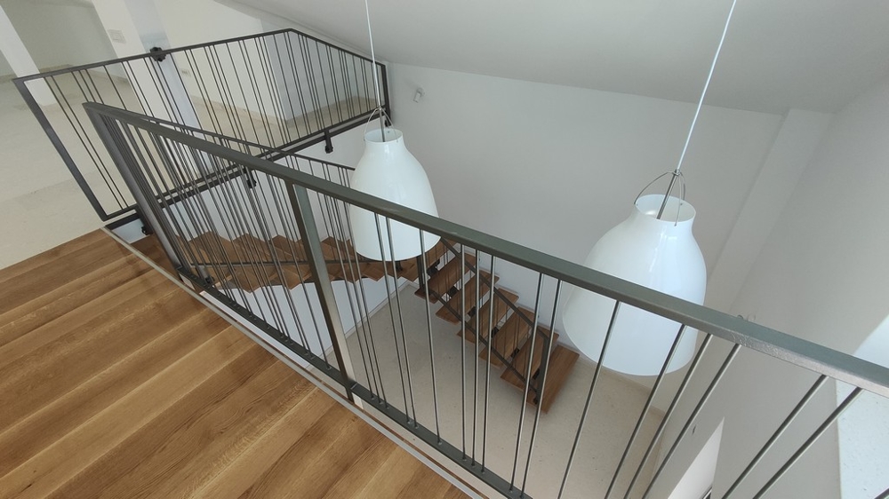 Penthouse for sale Croatia - Modern penthouse gallery with simple metal railings and white designer lights, with a view of the elegant staircase, available via Panorama Scouting.