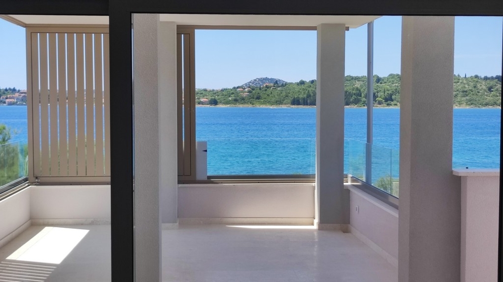 Real Estate Croatia - Modern penthouse with spacious, open living area, floor-to-ceiling windows and direct sea views, offered by Panorama Scouting.
