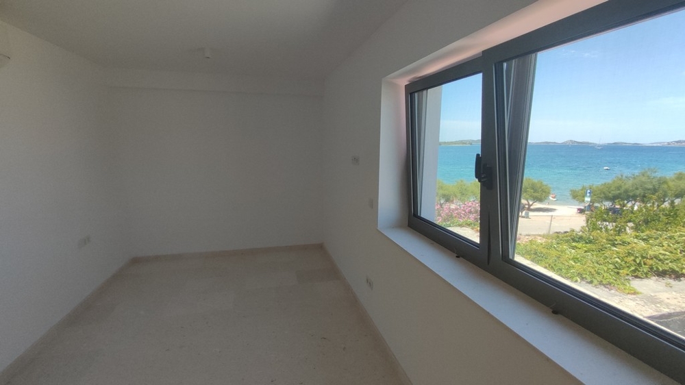 Penthouse for sale Croatia - Bright penthouse with a spacious room and large windows offering picturesque views of the sea and green surroundings, from Panorama Scouting.