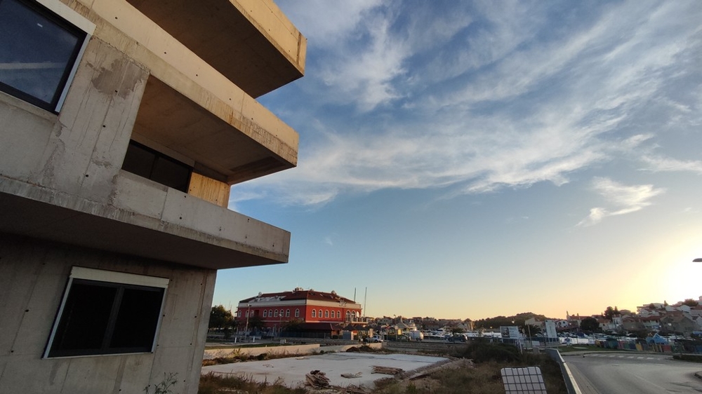 Partial view of a stylish new apartment complex at dawn in Tribunj, Vodice, surrounded by natural beauty, ideal for buyers.
