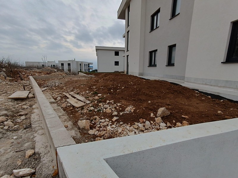 Side view of a new apartment building with unfinished landscaping and clear boundaries in Kostrena, Croatia