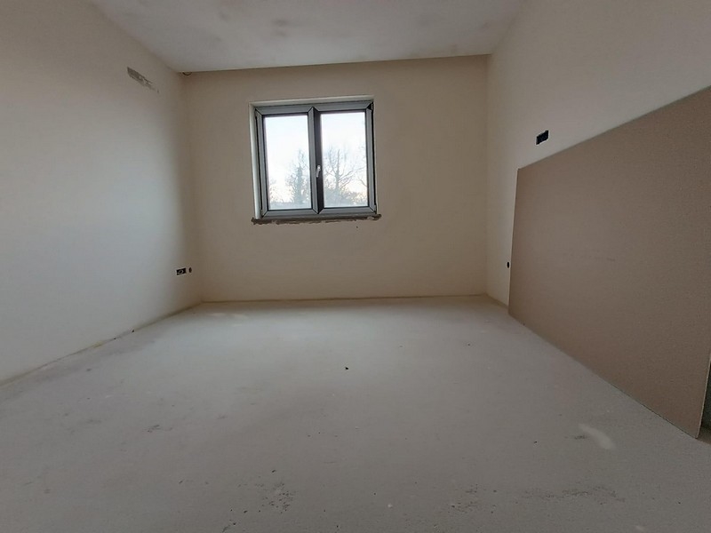 Unfurnished room with fresh plaster and two windows, ready for finishing touches in a new Croatian apartment