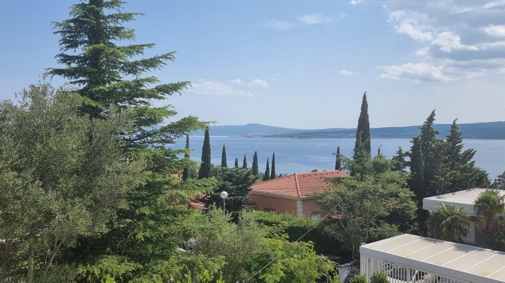 View from a balcony in Crikvenica, Croatia, with lush greenery and clear views of the Adriatic Sea, offered by Panorama Scouting.