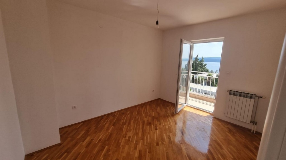 Spacious unfurnished room with polished parquet floors and balcony door with sea views, part of an apartment for sale in Crikvenica from Panorama Scouting.