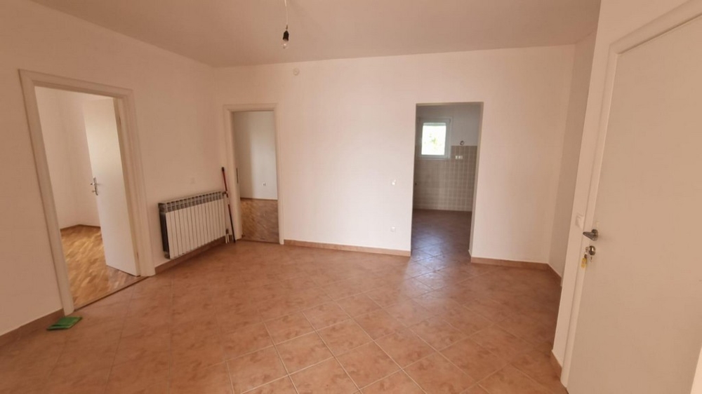 Large, unfurnished living space with tiled floors and multiple passages, in an apartment for sale in Crikvenica, presented by Panorama Scouting.