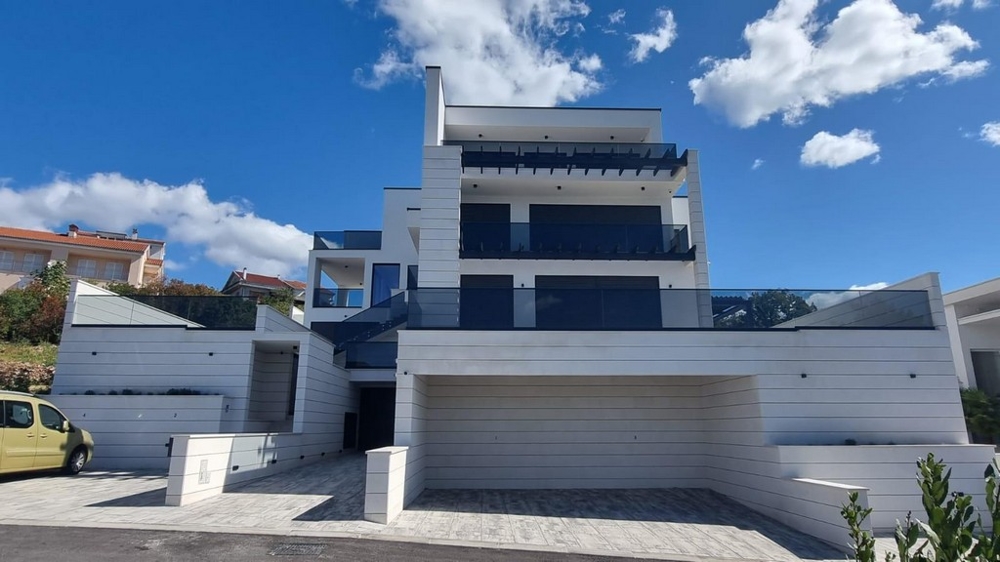 Front view of a contemporary new building in Croatia with several floors and a garage area.