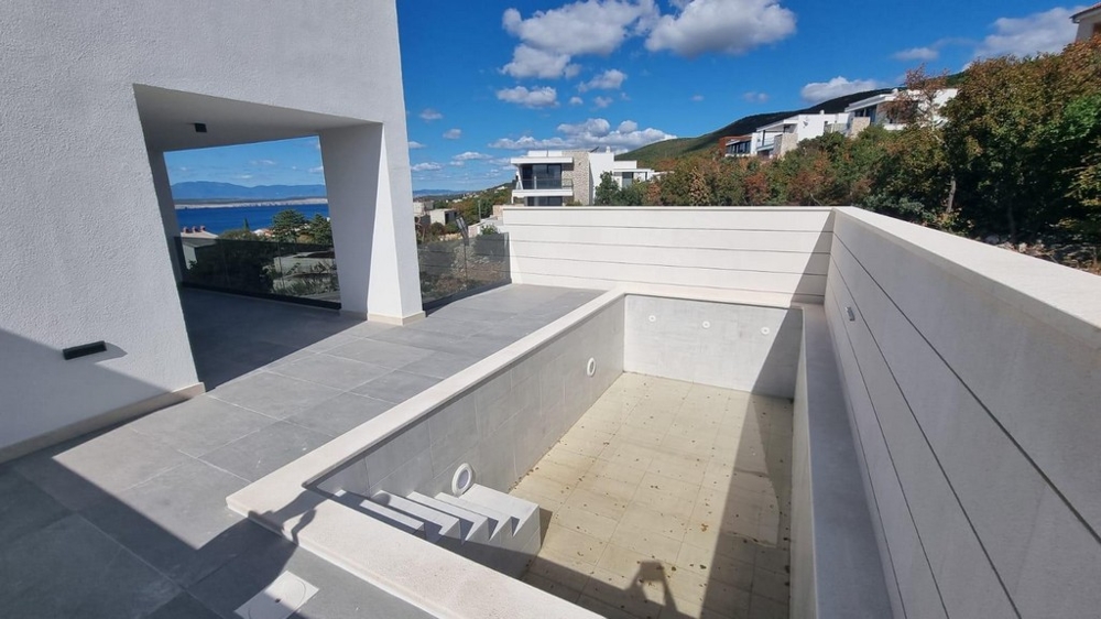 Outdoor area of ​​an apartment in Croatia with unfinished private swimming pool and sea views.