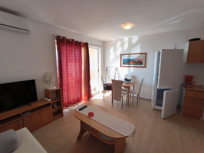 Further view of the living room with TV, air conditioning and balcony door, ideal for a seaside apartment in Croatia.