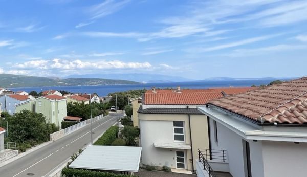 View of the sea and red roof tiles of real estate in Croatia under a clear sky
