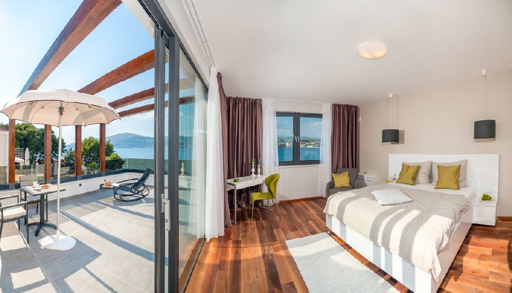 Bedroom with double bed and large window front with exit to the balcony with sea view.