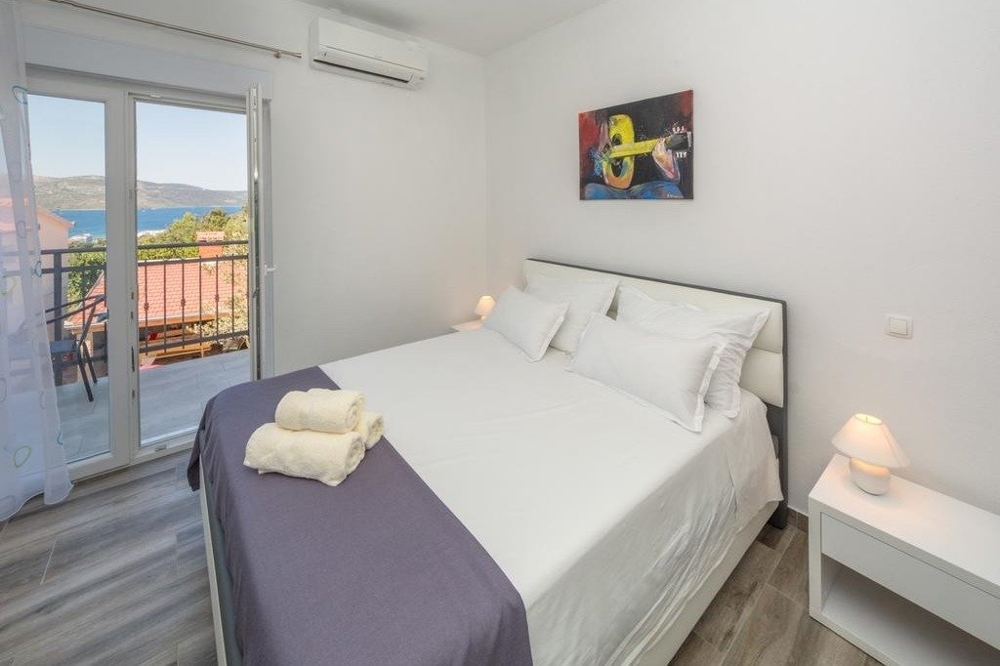 A bedroom with a double bed and a balcony in Croatia.