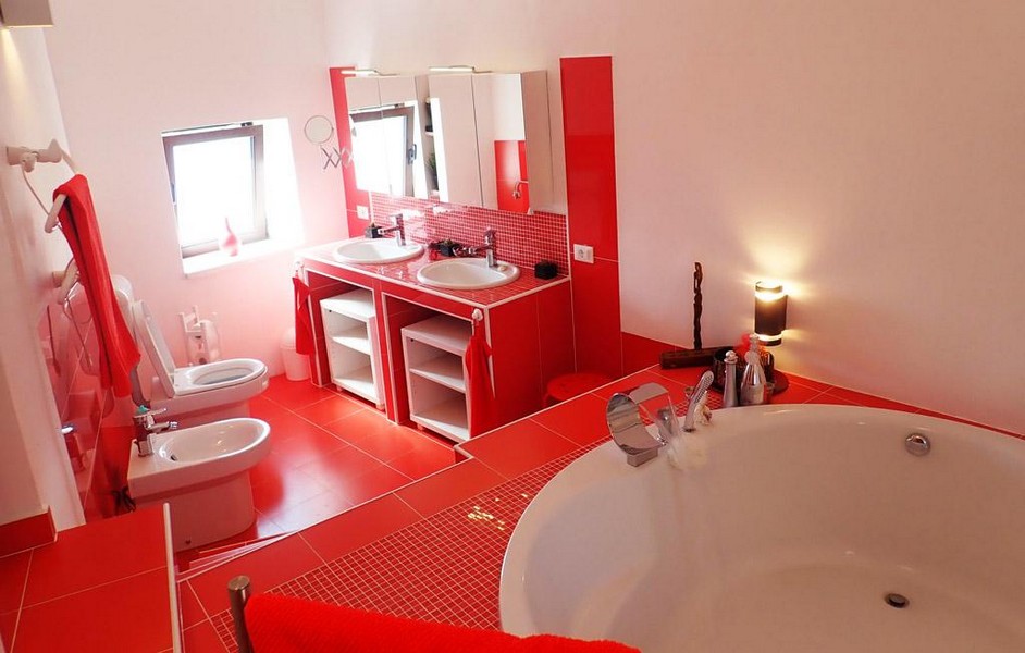 A modern bathroom with bathtub, toilet, bidet and window of the property.