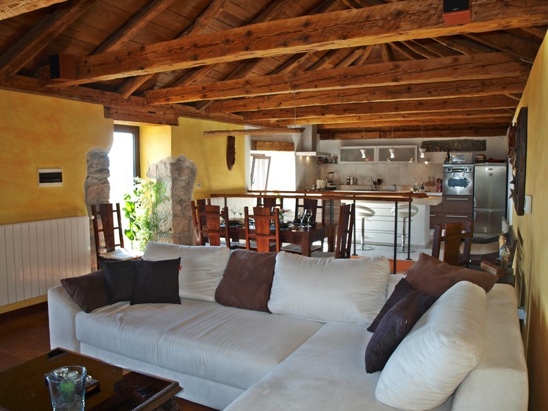 View of the open living room with dining area and kitchen on the upper floor of the property.