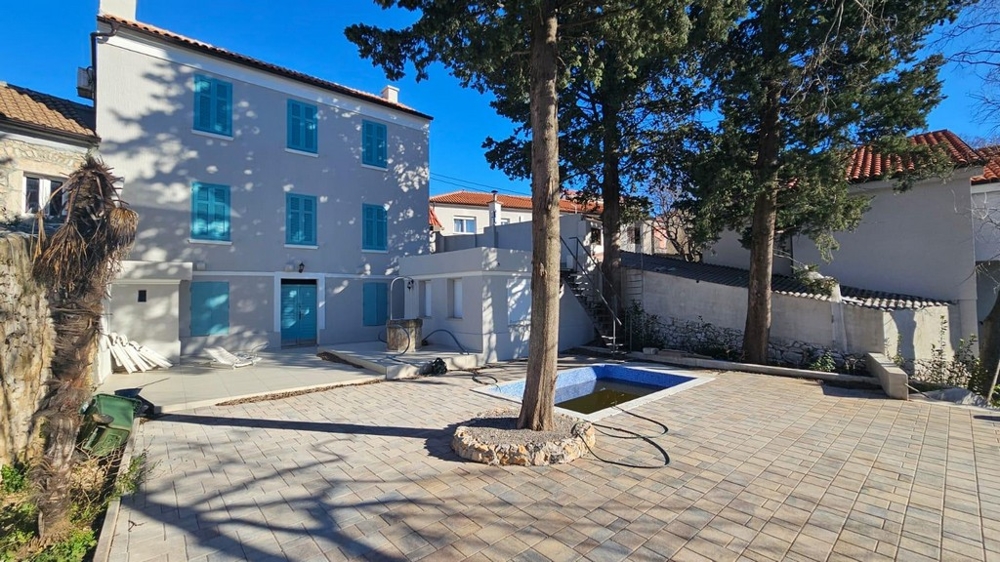 Panorama Scouting H2871: Rear view of house with pool and paved yard under clear blue sky.