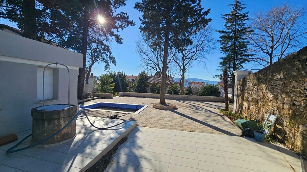 Sunlit outdoor area with swimming pool and cityscape views.
