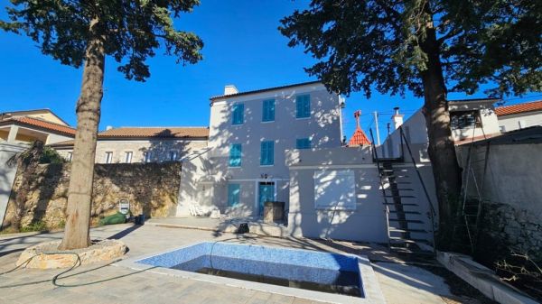 Buy a house Croatia - Panorama Scouting H2871: Exterior view of a renovated townhouse with swimming pool and trees in Novi Vinodolski.