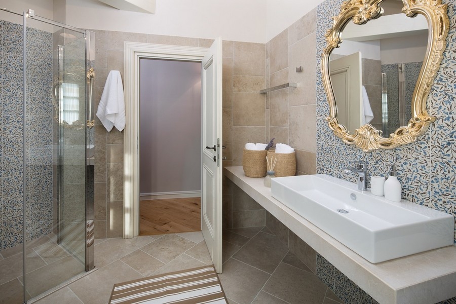 Modern bathroom with glass shower cubicle, patterned tiles and gold-framed mirror - Buy villa Croatia H2879