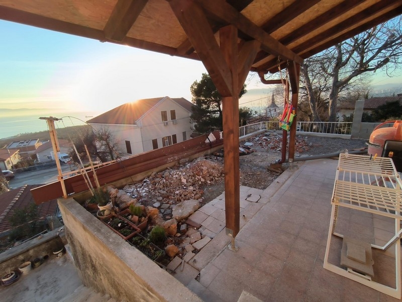 Covered terrace of a property in Croatia with a view of the garden and demolition remains