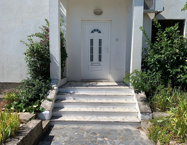 Entrance area of ​​the house in Croatia with white door and stone steps