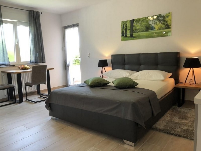 Modern bedroom in a property in Croatia with a large bed and art on the wall