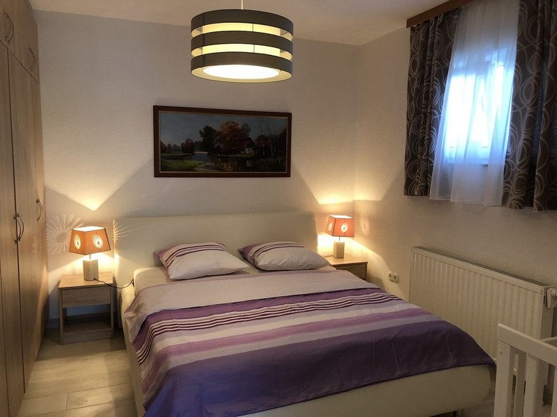 Cozy bedroom with purple bedding and mood lighting in a property in Croatia