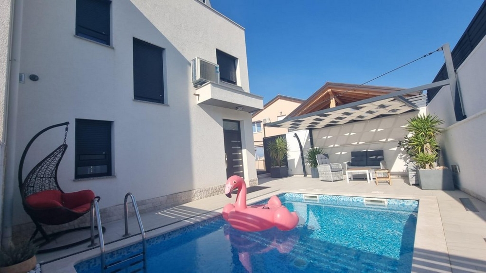 Exterior view of a property in Croatia with a pool and loungers