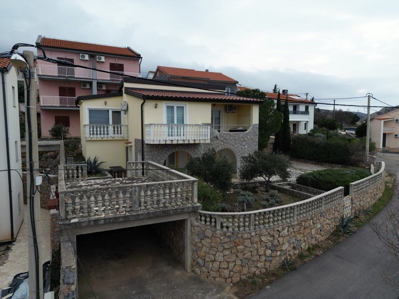 General view of house for sale in Karlobag with garage and surrounding wall
