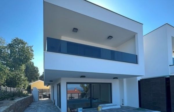 Modern residential building in Njivice with clear lines and balcony, representative of Croatia real estate.